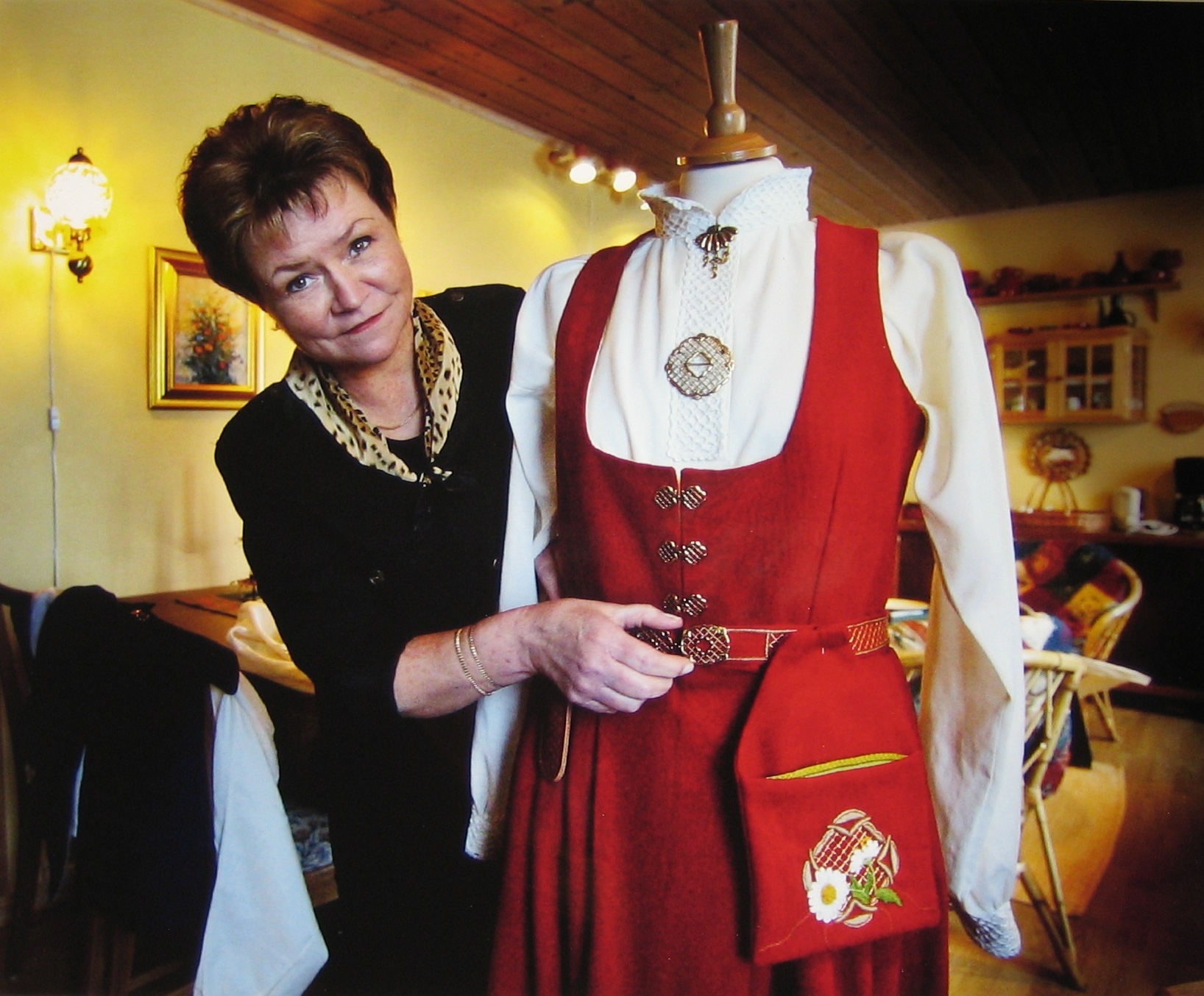 Liv M. Hansen viser Borgfestdrakt på monter – broderi, søljer, belte og løslomme